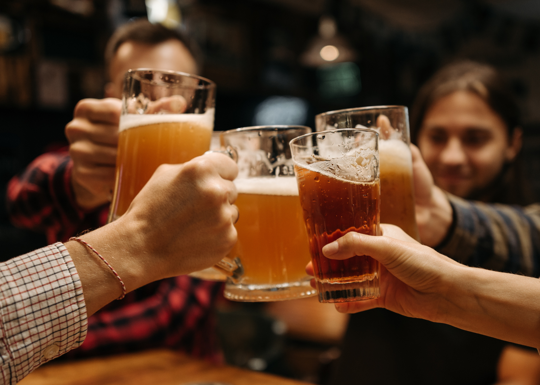 Group of people clinking their beer glasses together